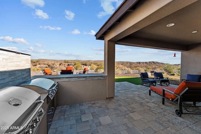 view of patio featuring a mountain view, a grill, and exterior kitchen