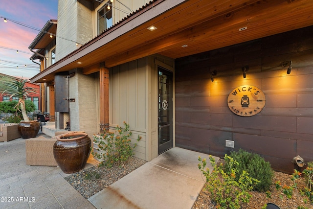 exterior entry at dusk featuring a patio