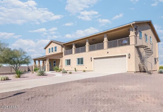 view of front of home with stairs, an attached garage, driveway, and stucco siding