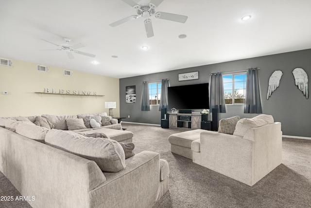 carpeted living area with plenty of natural light, a ceiling fan, and visible vents