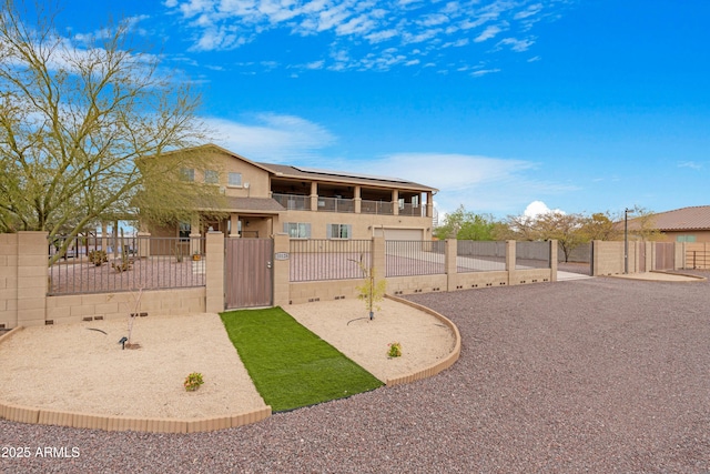 view of front of house with a fenced front yard, stucco siding, and a gate