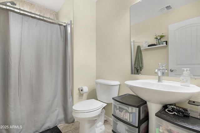 bathroom with visible vents, baseboards, toilet, a shower with shower curtain, and a sink