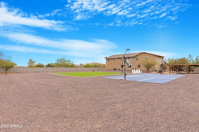 exterior space featuring community basketball court and fence