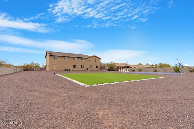 back of property featuring a lawn, fence, and stucco siding