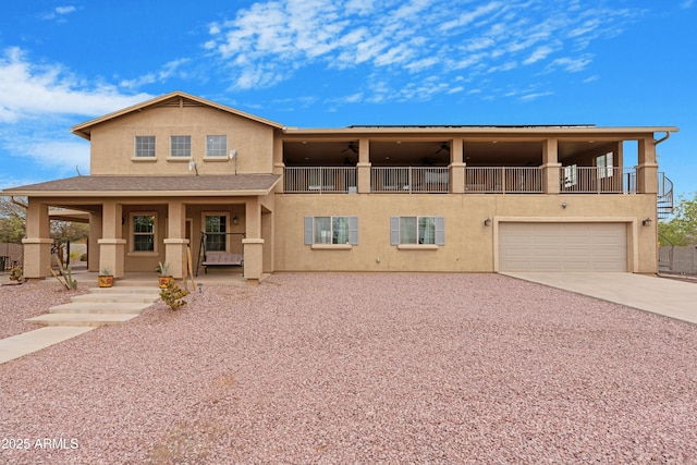 view of front of property with stucco siding, driveway, a porch, a garage, and a balcony