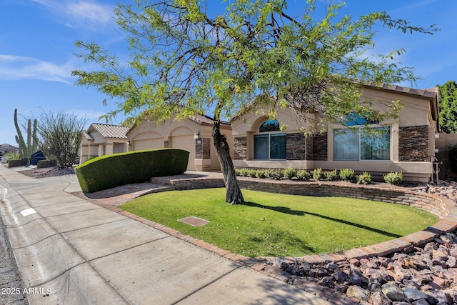 mediterranean / spanish home with stucco siding, a front lawn, and stone siding