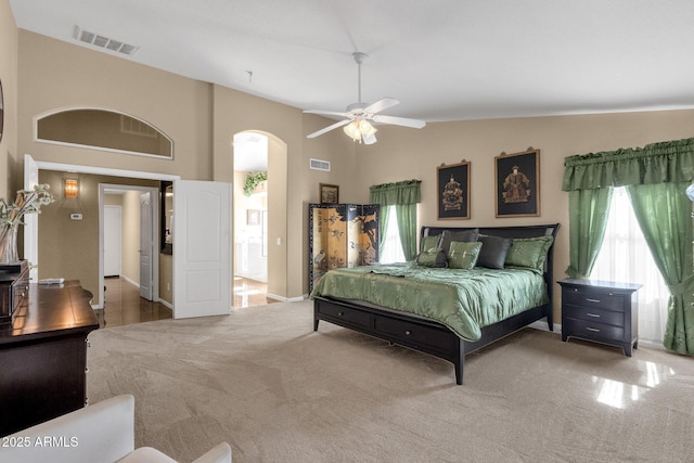 bedroom featuring arched walkways, multiple windows, carpet floors, baseboards, and high vaulted ceiling