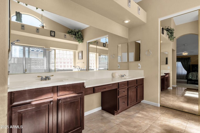 ensuite bathroom with double vanity, a ceiling fan, tile patterned flooring, and baseboards
