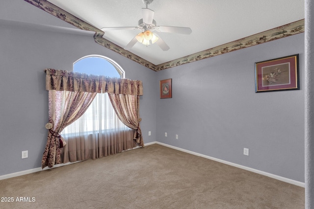 spare room with carpet, ceiling fan, baseboards, and vaulted ceiling