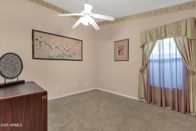 unfurnished office with carpet flooring, ceiling fan, and baseboards