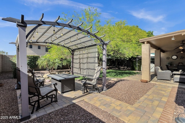 view of patio featuring a ceiling fan, a fenced backyard, a pergola, and an outdoor living space with a fire pit