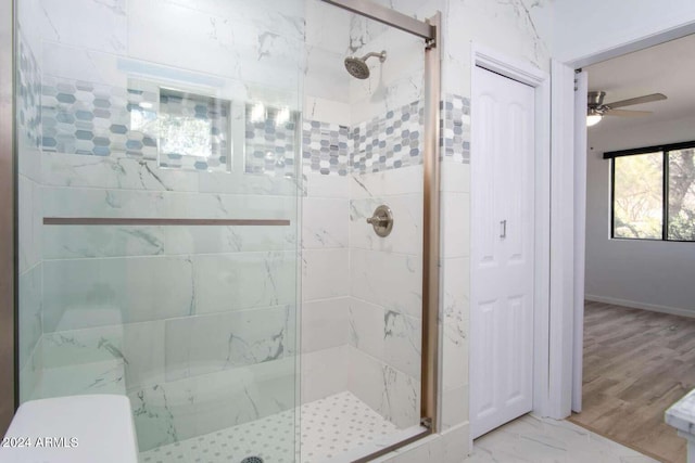 bathroom featuring ceiling fan, a shower with shower door, and hardwood / wood-style floors