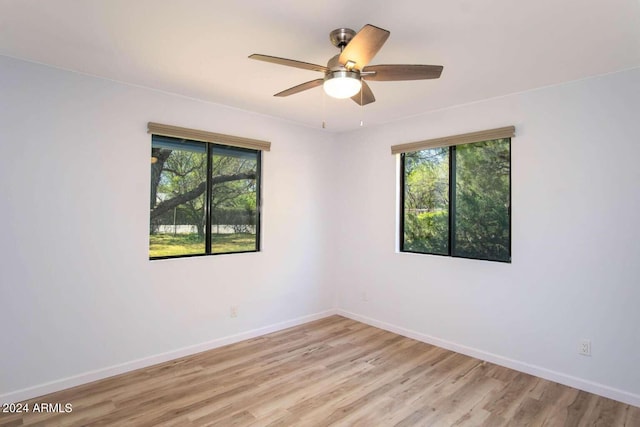 unfurnished room featuring ceiling fan, light hardwood / wood-style flooring, and a wealth of natural light