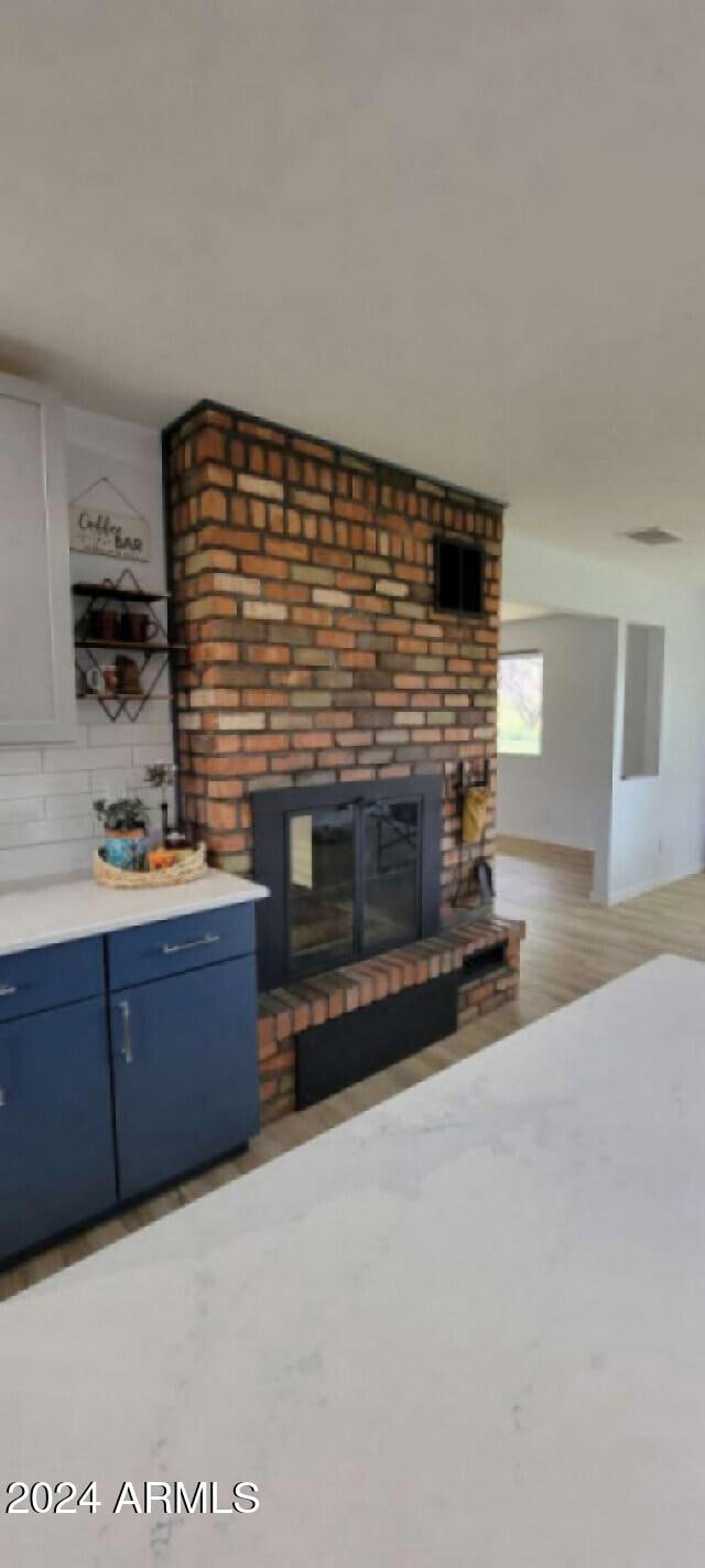 unfurnished living room featuring a brick fireplace and light hardwood / wood-style floors