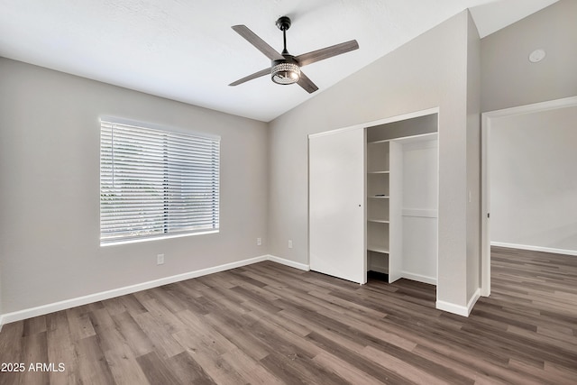 unfurnished bedroom with a closet, vaulted ceiling, ceiling fan, and dark hardwood / wood-style flooring