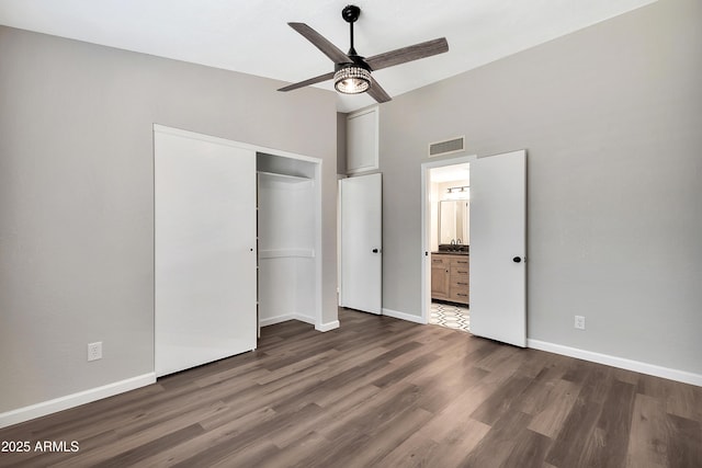 unfurnished bedroom with ceiling fan, connected bathroom, dark hardwood / wood-style floors, and a closet