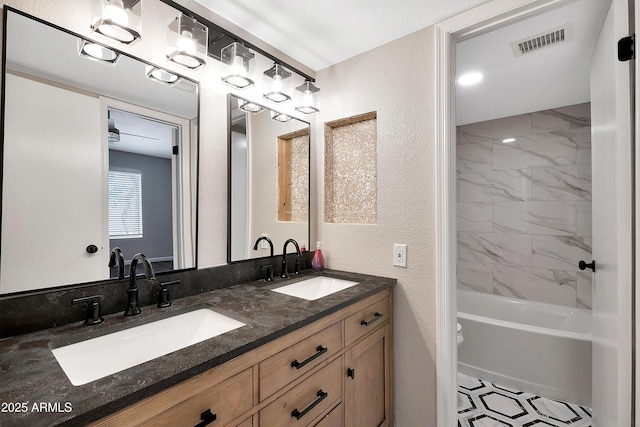 bathroom featuring tiled shower / bath combo and vanity