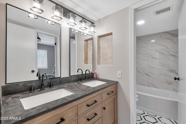 full bathroom featuring vanity, toilet, and tiled shower / bath