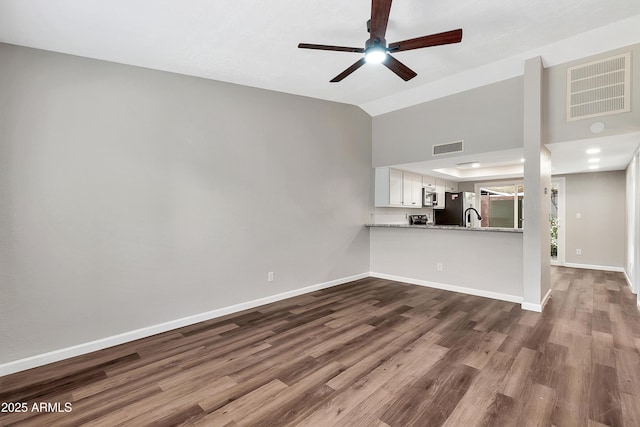 unfurnished living room with hardwood / wood-style flooring, ceiling fan, and vaulted ceiling