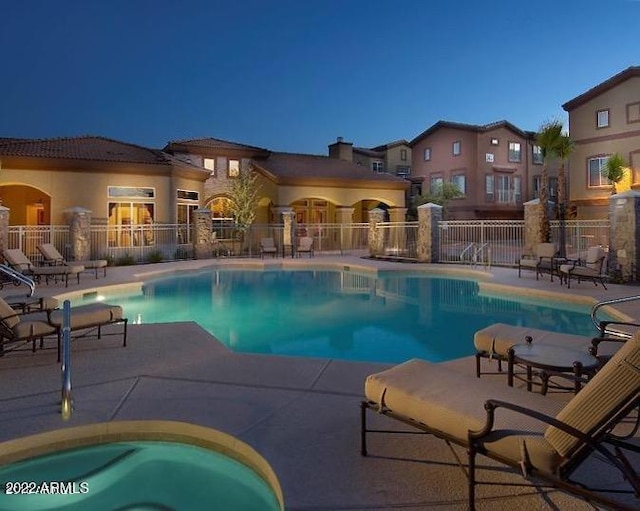 community pool with a patio and fence