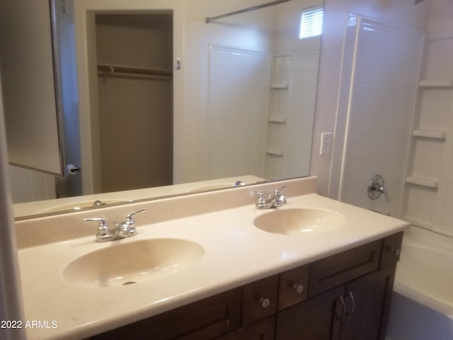 bathroom featuring a sink, shower / bathing tub combination, and double vanity