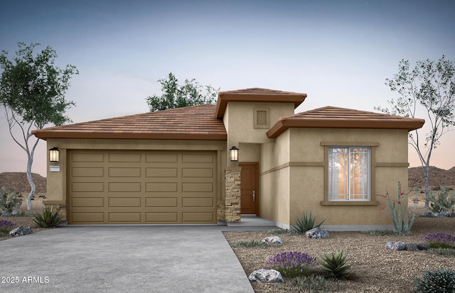 prairie-style home featuring a garage, stone siding, driveway, and stucco siding