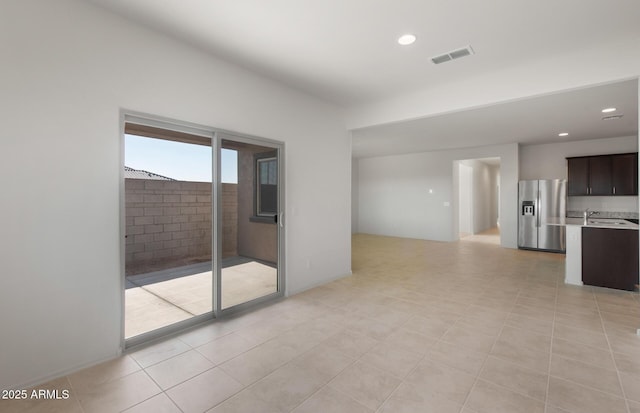 unfurnished living room with recessed lighting, visible vents, and a sink