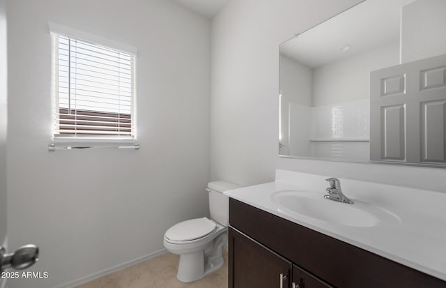 bathroom with tile patterned flooring, toilet, vanity, baseboards, and walk in shower