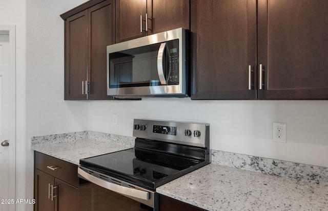 kitchen with light stone countertops, stainless steel appliances, and dark brown cabinets