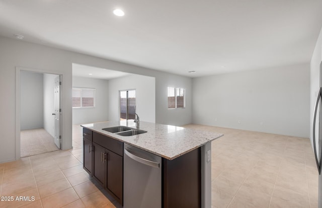 kitchen featuring open floor plan, a sink, an island with sink, dark brown cabinets, and dishwasher