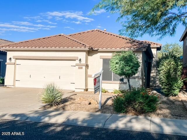 40618 N Apollo Way, Anthem, AZ 85086 - mediterranean / spanish-style house featuring a garage, driveway, a tile roof, and stucco siding