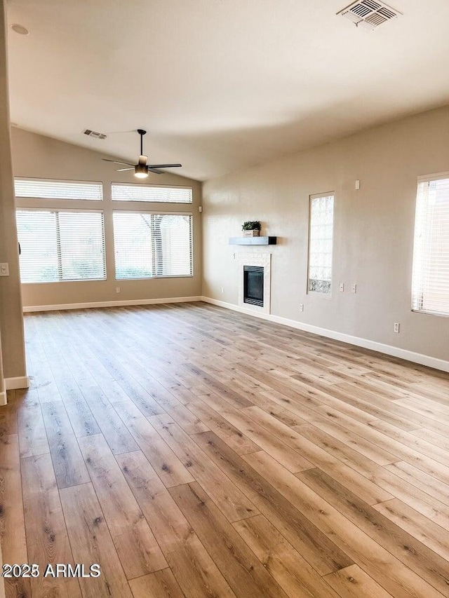 40618 N Apollo Way, Anthem, AZ 85086 - unfurnished living room with hardwood / wood-style flooring, baseboards, ceiling fan, and a glass covered fireplace