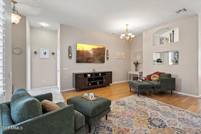 living room with light hardwood / wood-style floors and an inviting chandelier