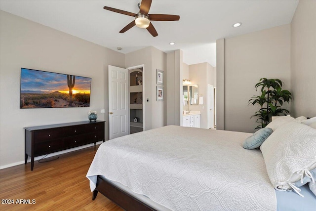 bedroom with connected bathroom, hardwood / wood-style flooring, and ceiling fan