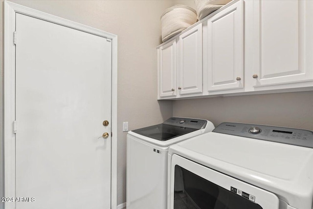 laundry room featuring washing machine and dryer and cabinets