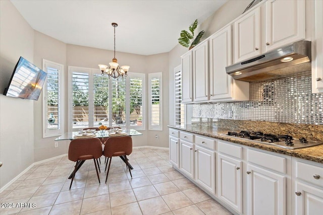 kitchen with white cabinets, stainless steel gas stovetop, a notable chandelier, and hanging light fixtures