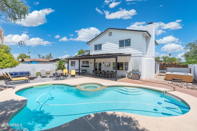 view of pool with a patio area, a fenced in pool, a fenced backyard, and a hot tub