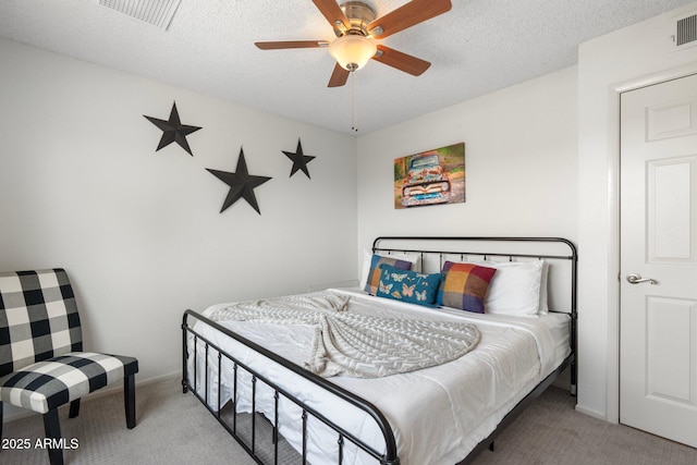 bedroom with ceiling fan, light colored carpet, and a textured ceiling