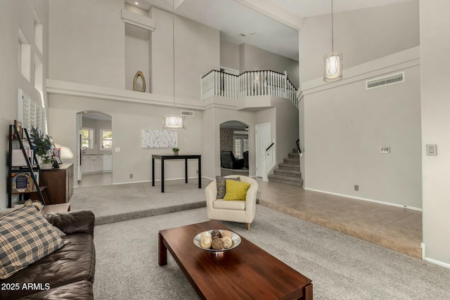 16047 S 14th Dr, Phoenix, AZ 85045 - carpeted living area featuring arched walkways, a towering ceiling, visible vents, and stairway