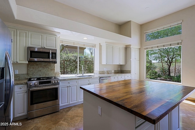 32710 N 71st St, Scottsdale, AZ 85266 - kitchen with appliances with stainless steel finishes, wooden counters, decorative backsplash, stone finish flooring, and white cabinetry