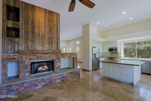 32710 N 71st St, Scottsdale, AZ 85266 - kitchen featuring stainless steel appliances, a fireplace, butcher block countertops, white cabinetry, and a kitchen island