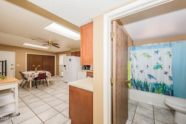 interior space featuring ceiling fan, white appliances, a textured ceiling, and light tile patterned flooring