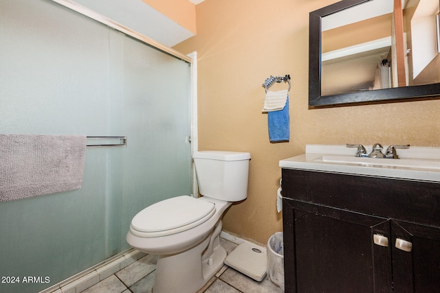 bathroom featuring tile patterned flooring, vanity, toilet, and an enclosed shower