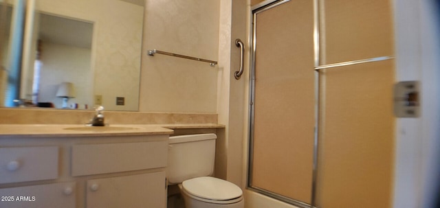 bathroom with vanity, toilet, and a shower with door