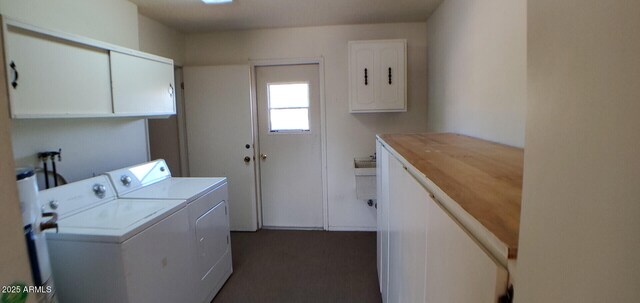 clothes washing area with washer and dryer and cabinets