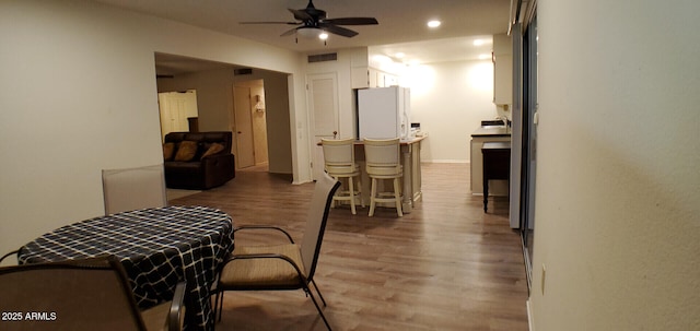 dining space with hardwood / wood-style flooring and ceiling fan