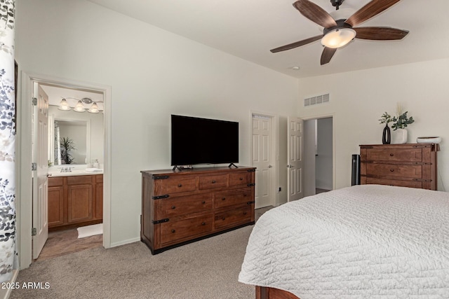 bedroom with lofted ceiling, light colored carpet, visible vents, a sink, and ensuite bath