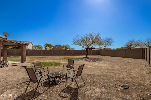 view of yard with a fenced backyard, a patio, and a fire pit