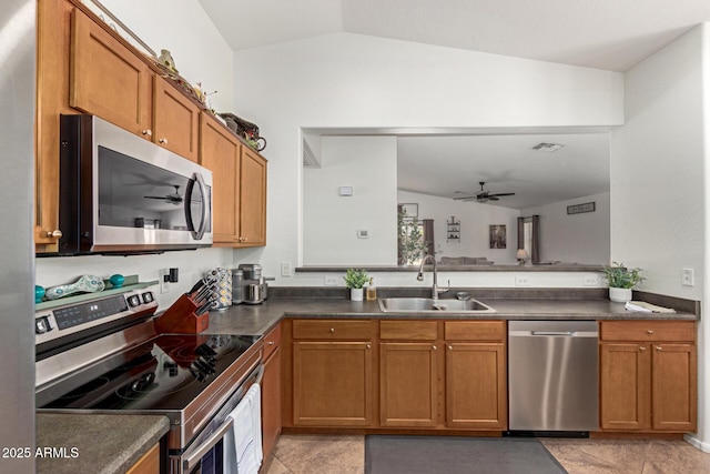 kitchen featuring stainless steel appliances, a sink, visible vents, brown cabinetry, and dark countertops