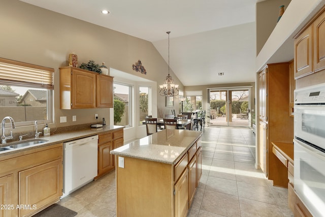 kitchen with lofted ceiling, a kitchen island, sink, a chandelier, and white dishwasher